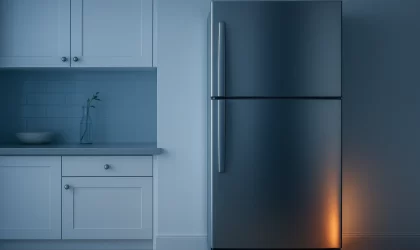 Stainless steel fridge in a modern Australian kitchen with warm compressor glow, illustrating a fridge running constantly.